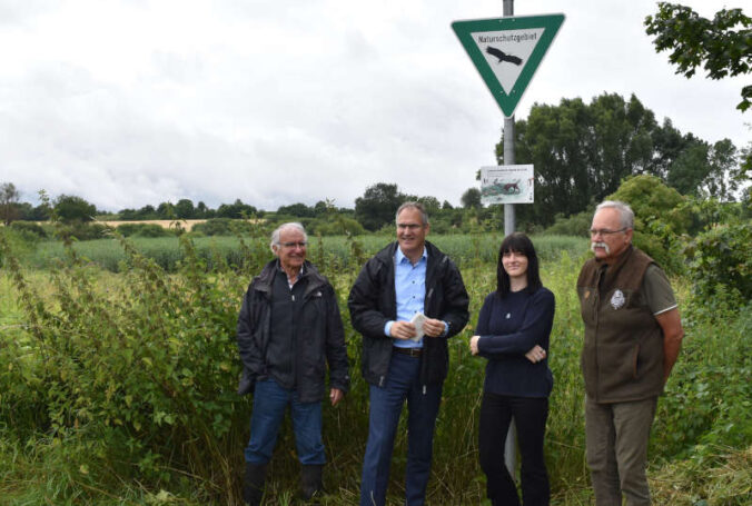 Das erste Schild hängt, weitere werden folgen: v.l. Kurt von Nida, Vorstand NVS NaturStiftung Südpfalz, Dietmar Seefeldt, Landrat Kreis Südliche Weinstraße, Maria Merrbach, Schilddesignerin NVS NaturStiftung Südpfalz, Klaus Walter, Vorsitzender Kreisgruppe SÜW im Landesjagdverband Rheinland-Pfalz. (Foto: NVS NaturStiftung Südpfalz)