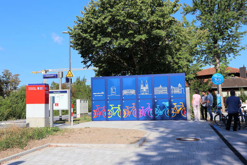 Der umgestaltete Vorplatz mit Parkplätzen und Fahrradabstellmöglichkeiten schließt sich nahtlos an den barrierefreien Bahnsteig an. Die blauen VRN-Radboxen können digital gebucht werden. (Quelle: Stadt Landau)