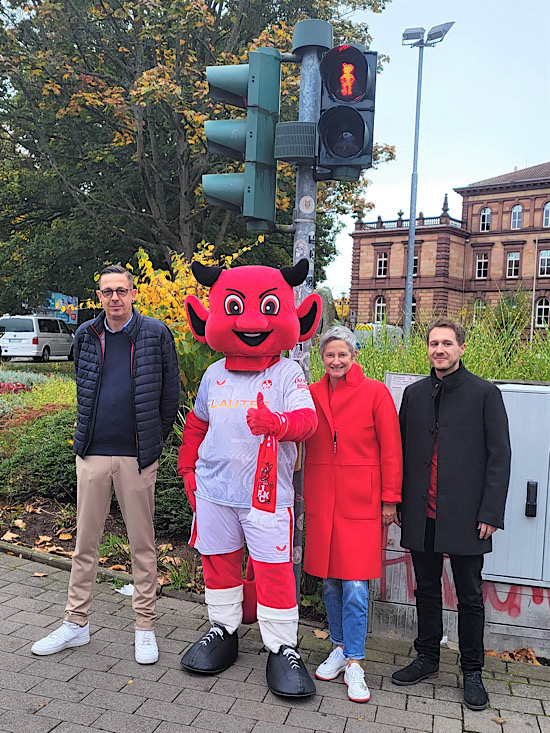 Stefan Roßkopf, Leiter der Unternehmenskommunikation des 1. FC Kaiserslautern, Betzi, Oberbürgermeisterin Beate Kimmel und Marc Herzer, Geschäftsführer der HCP Grauwild GmbH, freuen sich über das erste besondere Ampelmännchen in Kaiserslautern. (Foto: Stadt Kaiserslautern)