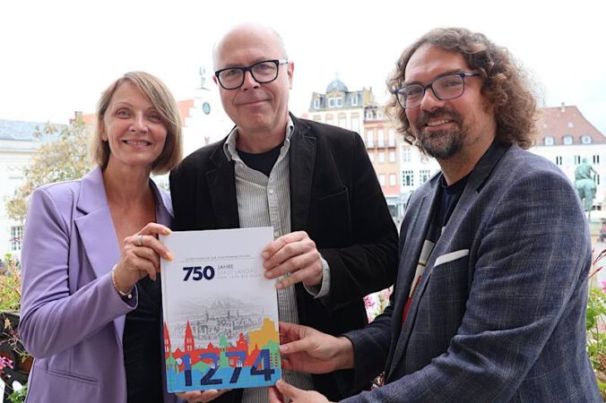 Oberbürgermeister Dominik Geißler (Mitte), Stadtdenkmalpfleger Jörg Seitz und Martina Becht, Bauzeichnerin beim Stadtbauamt, mit dem neuesten Band der Schriftenreihe. (Quelle: Stadt Landau)