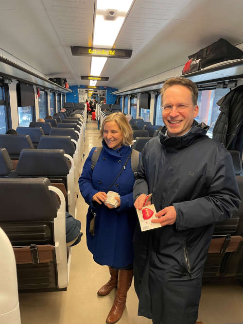 Landesmobilitätsministerin Katrin Eder und Verbandsdirektor Michael Heilmann verteilen in einem Regional-Express des SÜWEX-Netzes ein süßes Dankeschön fürs Bahnfahren (Foto: fritz engbarth/zöpnv)