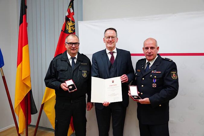 Innenminister Michael Ebling übergibt das Feuerwehr-Ehrenzeichen an Stefan Bohnenberger (l.) und Dirk Hargesheimer (r.). (Foto: Innenministerium RLP)