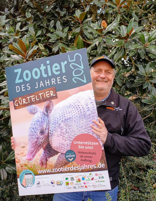 Zoodirektor Dr. Jens-Ove Heckel mit einem der Plakate, die in den Partnerzoos der Artenschutzkampagne für das „Zootier des Jahres 2025“ werben. (Quelle: Zoo Landau)